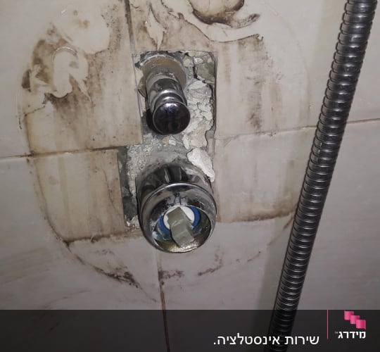 ברז מקולקל עם צינור מתכת במקלחת